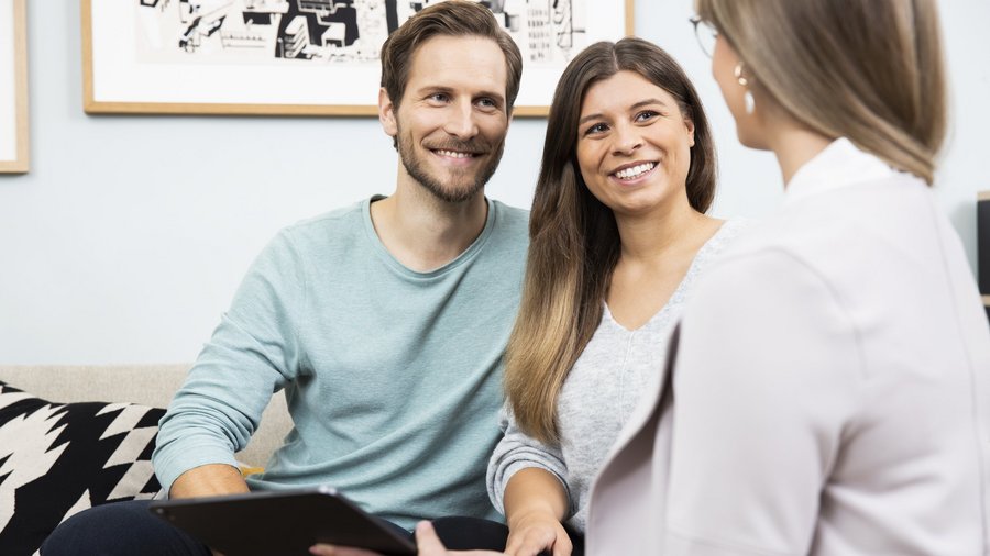 Finančná poradkyňa v rozhovore s mladým párom Finančná poradkyňa v rozhovore s mladým párom