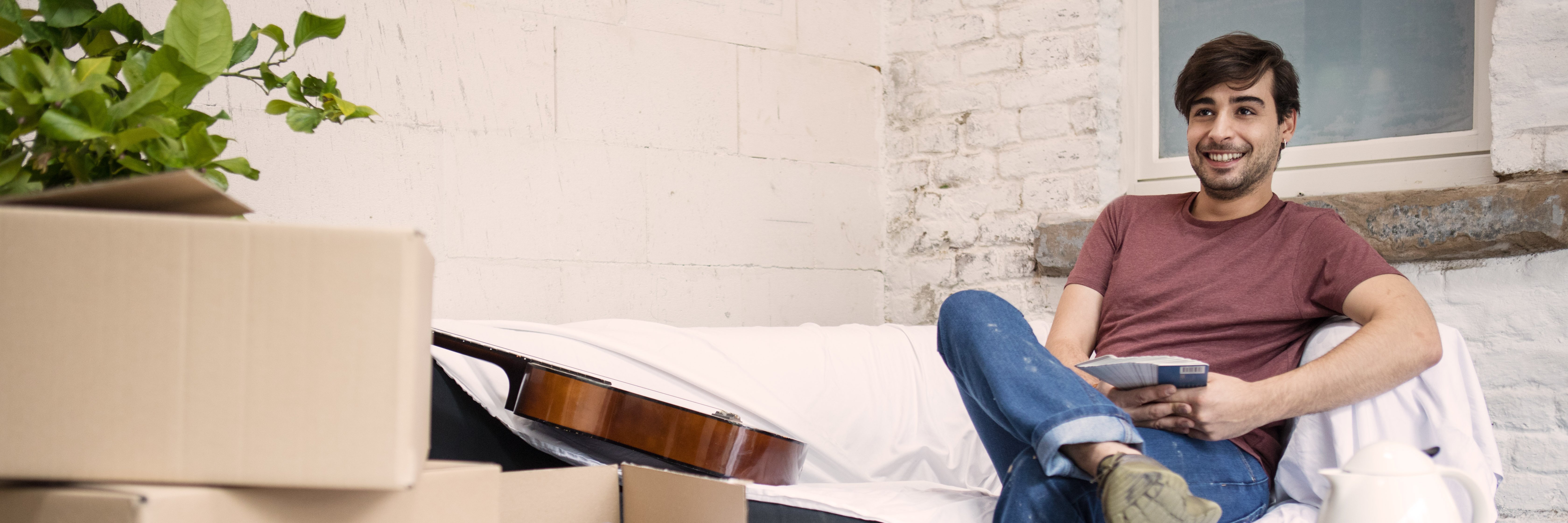 Muž sedí s úsmevom na gauči počas renovácie domu Muž sedí s úsmevom na gauči počas renovácie domu