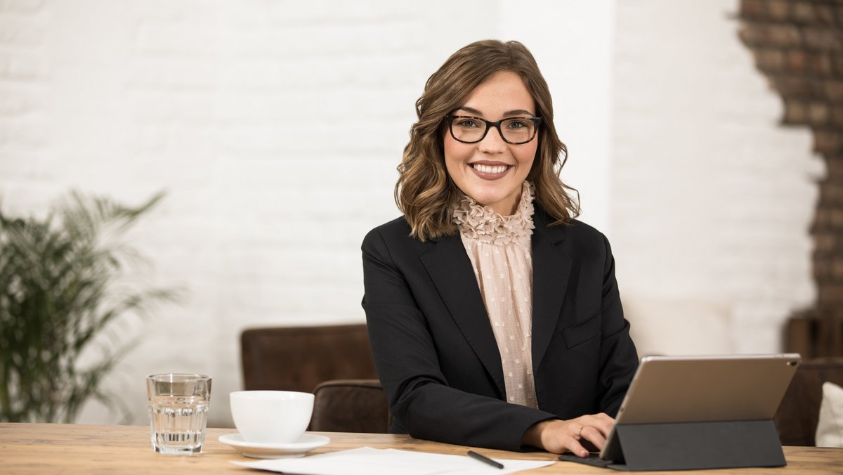 Finančná poradkyňa v kancelárii sa usmieva do kamery Finančná poradkyňa v kancelárii sa usmieva do kamery